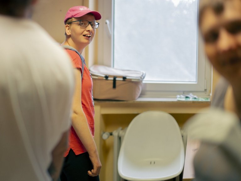 Bewohner mit pinken Cap und Brille schaut in die Kamera